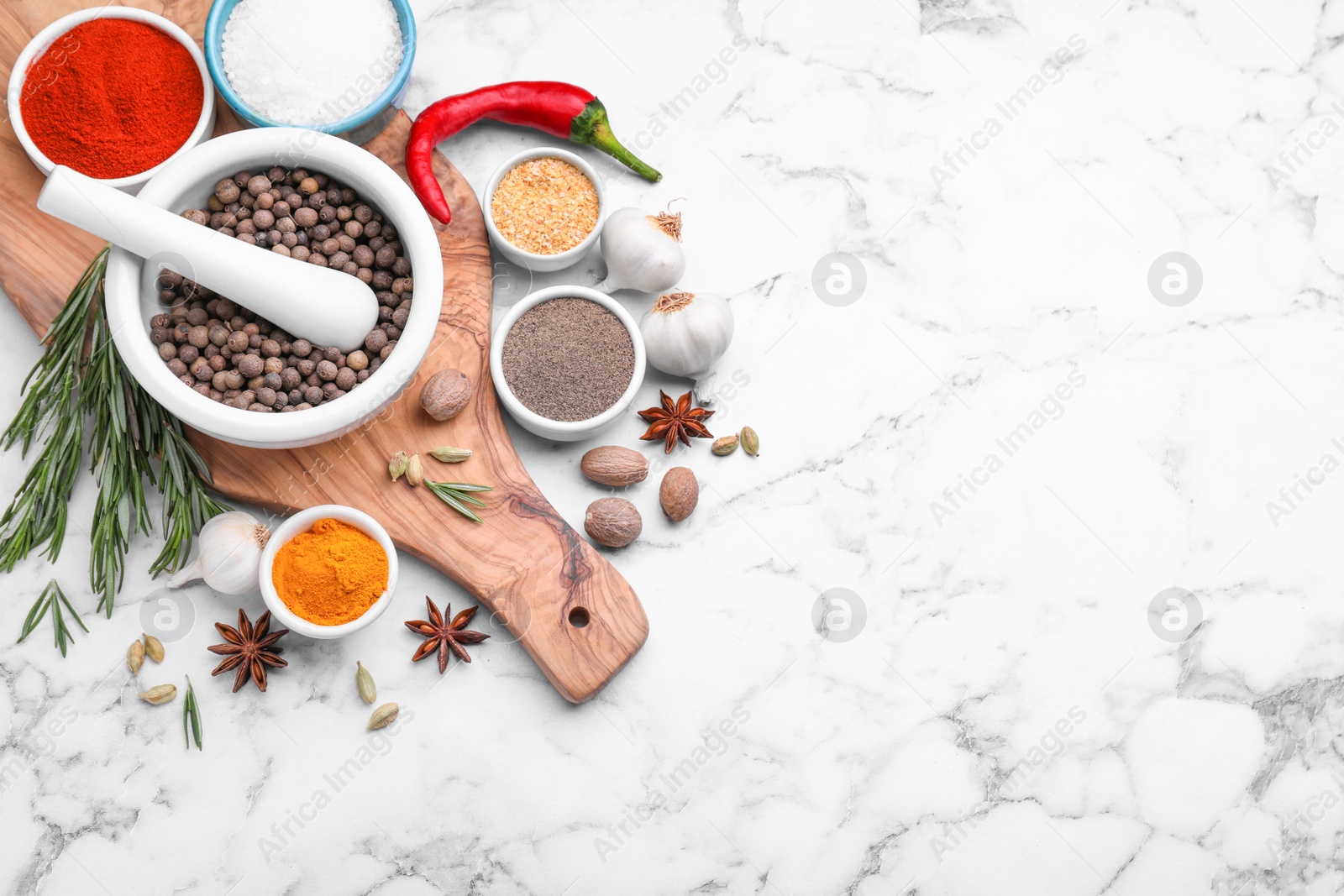 Photo of Flat lay composition with mortar and different spices on white marble table, space for text