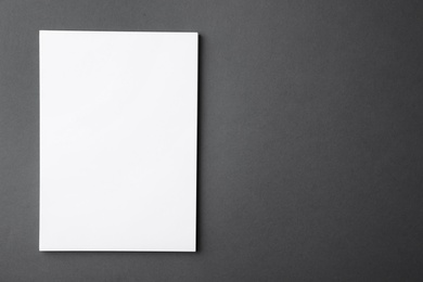 Photo of Blank paper sheets on dark grey background, top view. Mock up for design