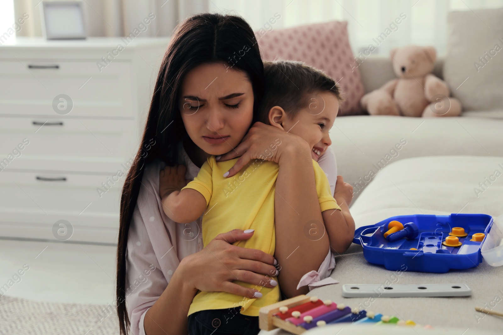 Photo of Depressed single mother with child in living room