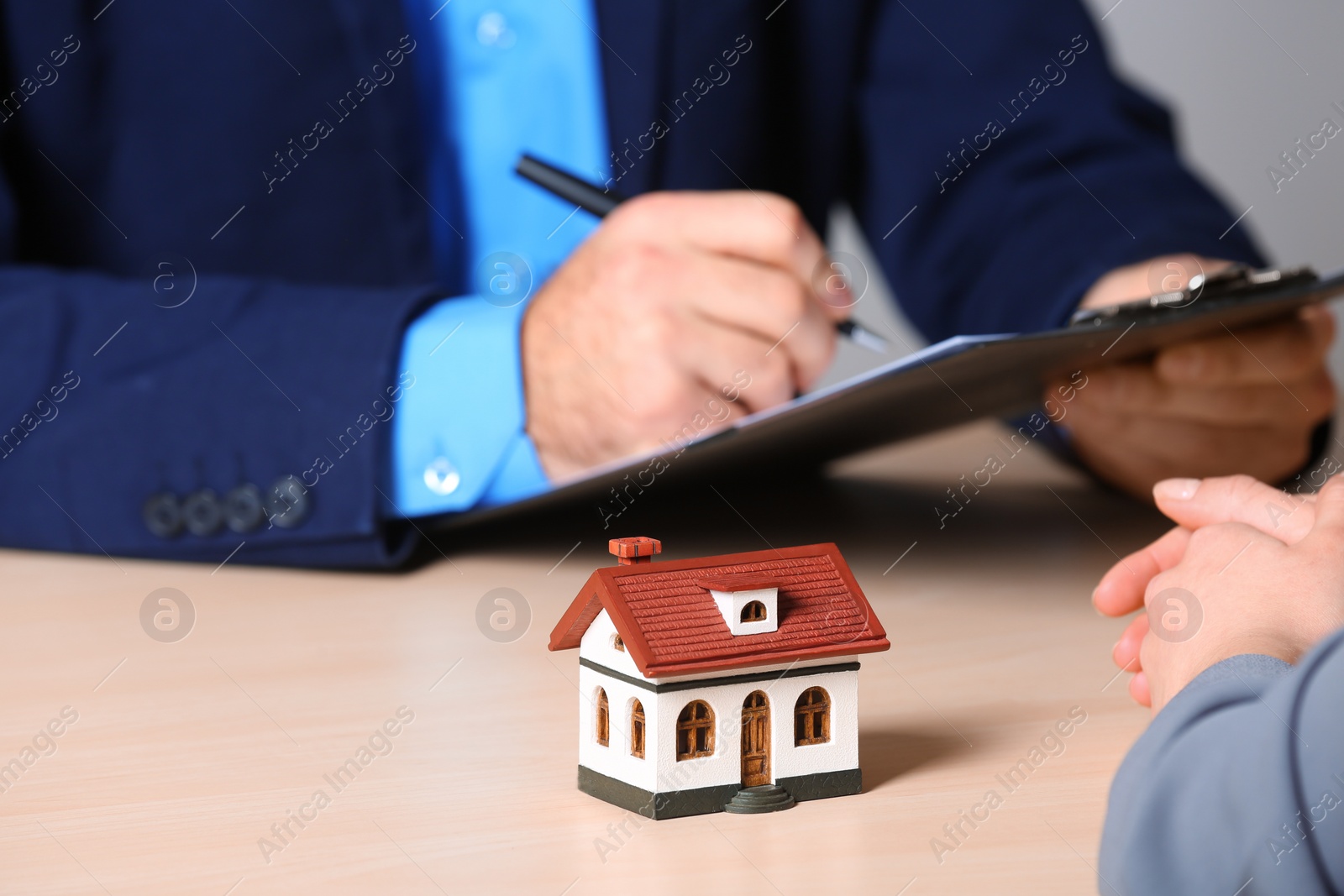 Photo of Real estate agent working with client at table in office, closeup. Home insurance