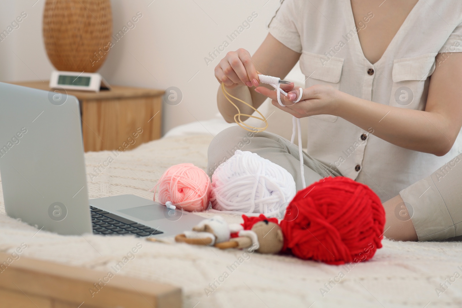 Photo of Woman learning to knit with online course at home, closeup. Handicraft hobby