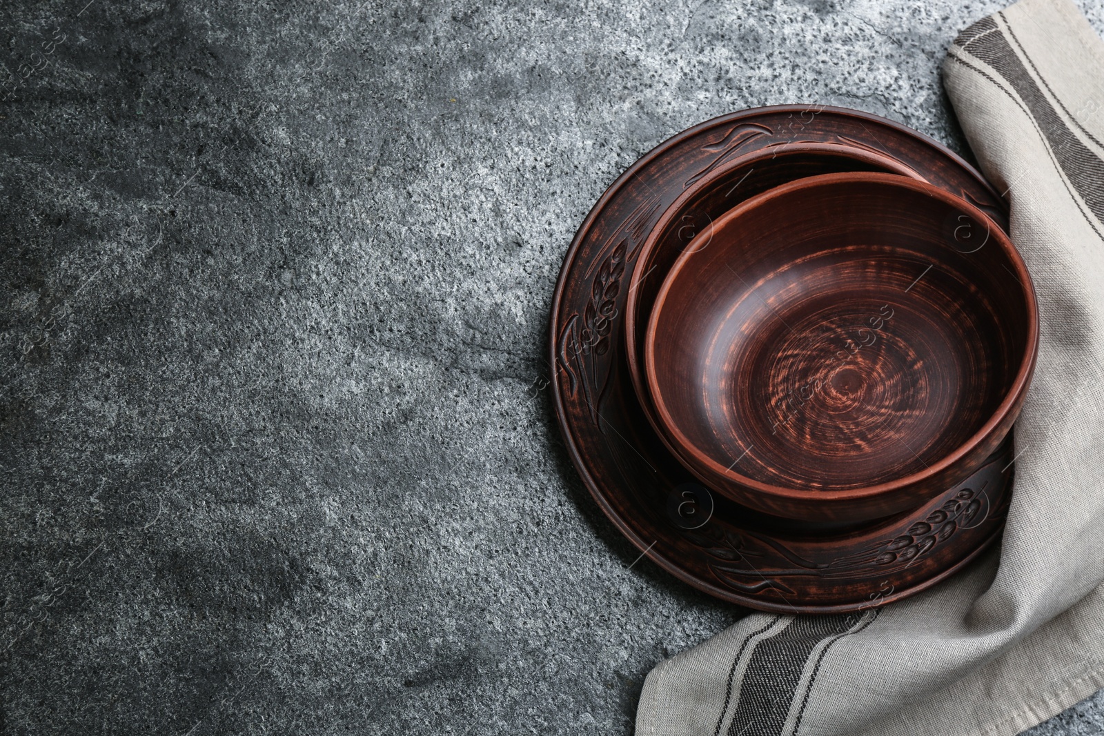 Photo of Set of clay utensils on grey table, flat lay. Space for text