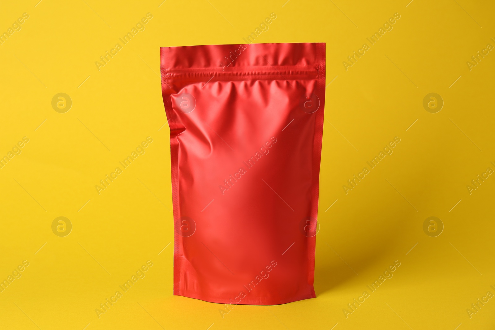 Photo of One blank foil package on yellow background