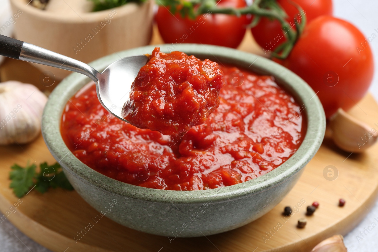 Photo of Eating homemade tomato sauce at light grey table, closeup