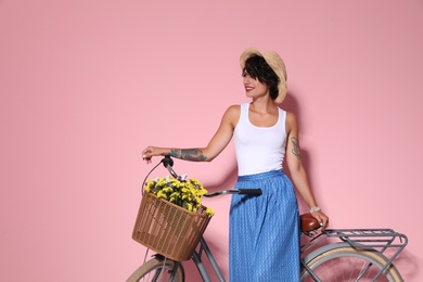 Photo of Portrait of beautiful young woman with bicycle on color background
