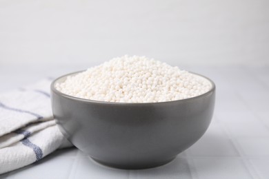 Tapioca pearls in bowl and towel on white tiled table