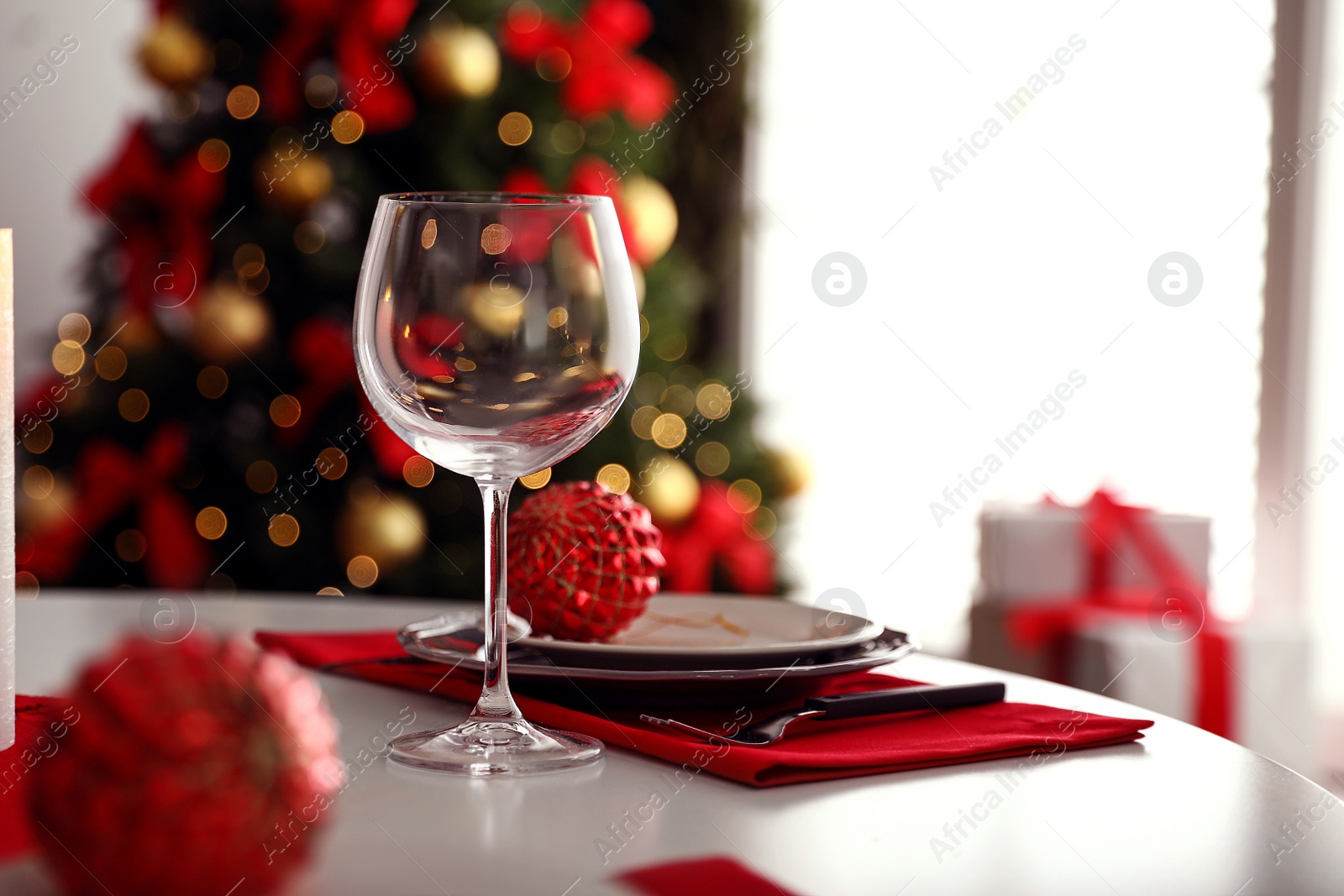 Photo of Festive table setting and Christmas tree in stylish room interior