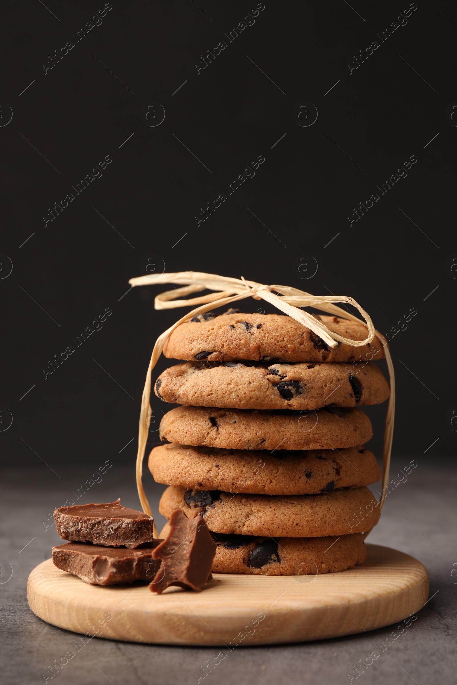 Photo of Stack of delicious chocolate chip cookies on grey table