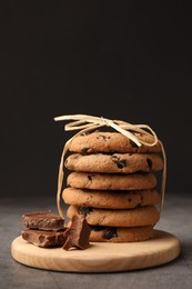 Photo of Stack of delicious chocolate chip cookies on grey table