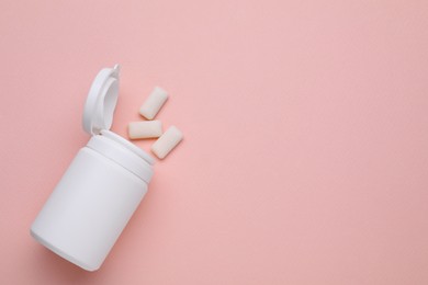 Photo of Jar with chewing gums on light pink background, flat lay. Space for text