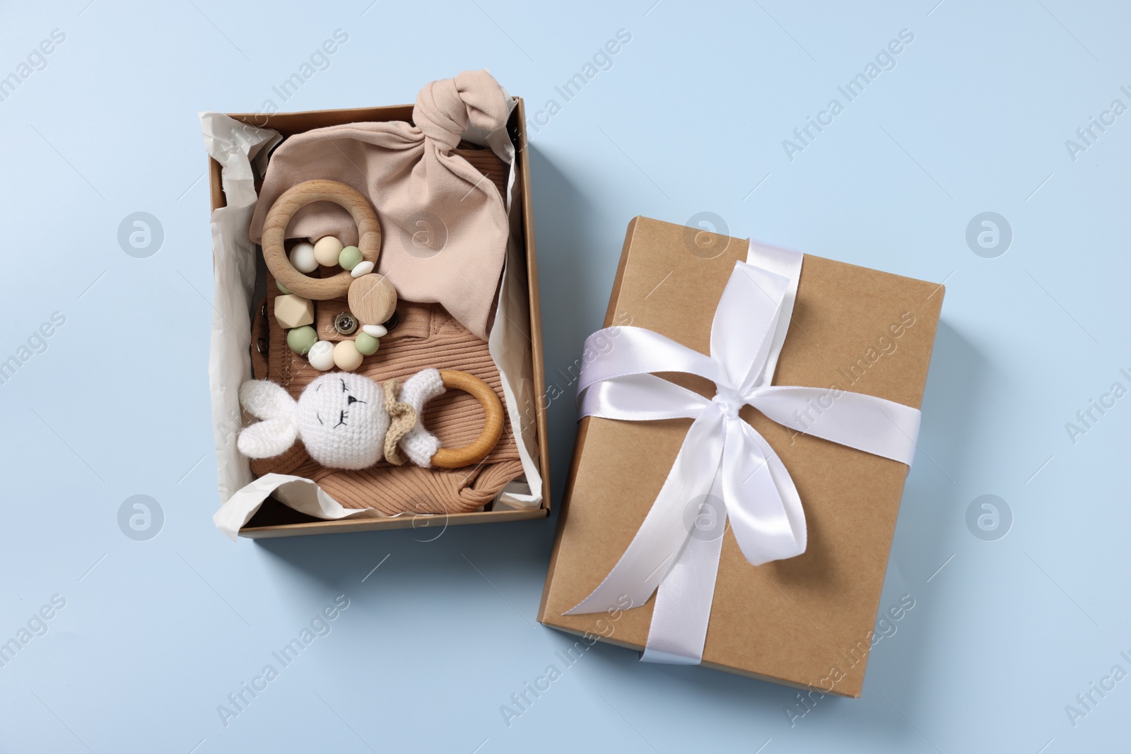 Photo of Different baby accessories in box on light blue background, flat lay
