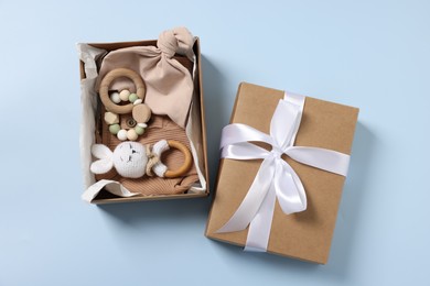 Different baby accessories in box on light blue background, flat lay