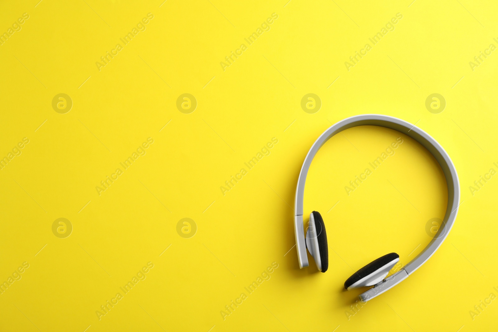 Photo of Wireless headphones on color background, top view. Space for text