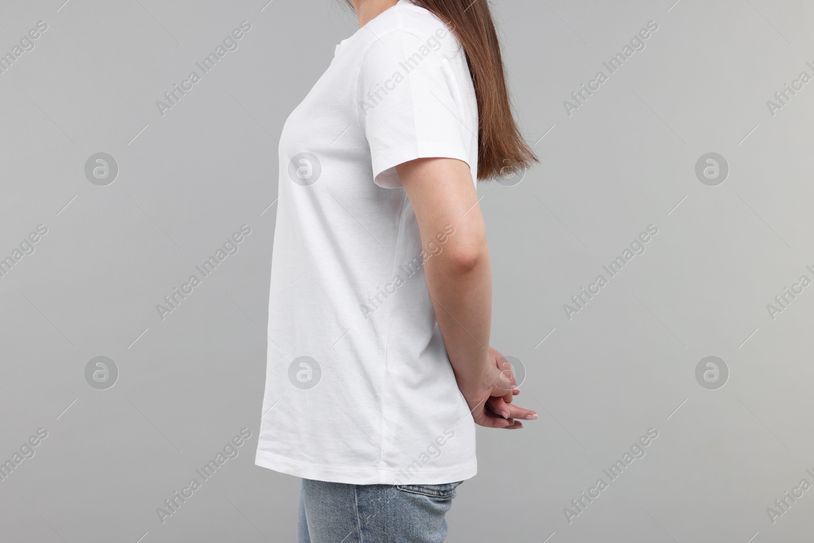 Photo of Woman in white t-shirt on grey background, closeup