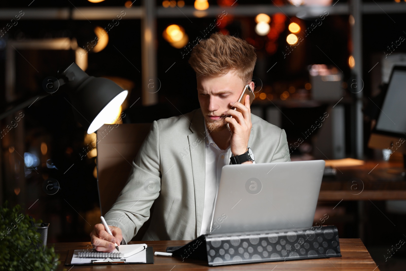 Photo of Young man working in office at night