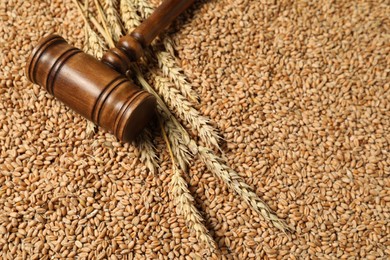 Wooden gavel and wheat ears on grains, closeup. Agricultural deal