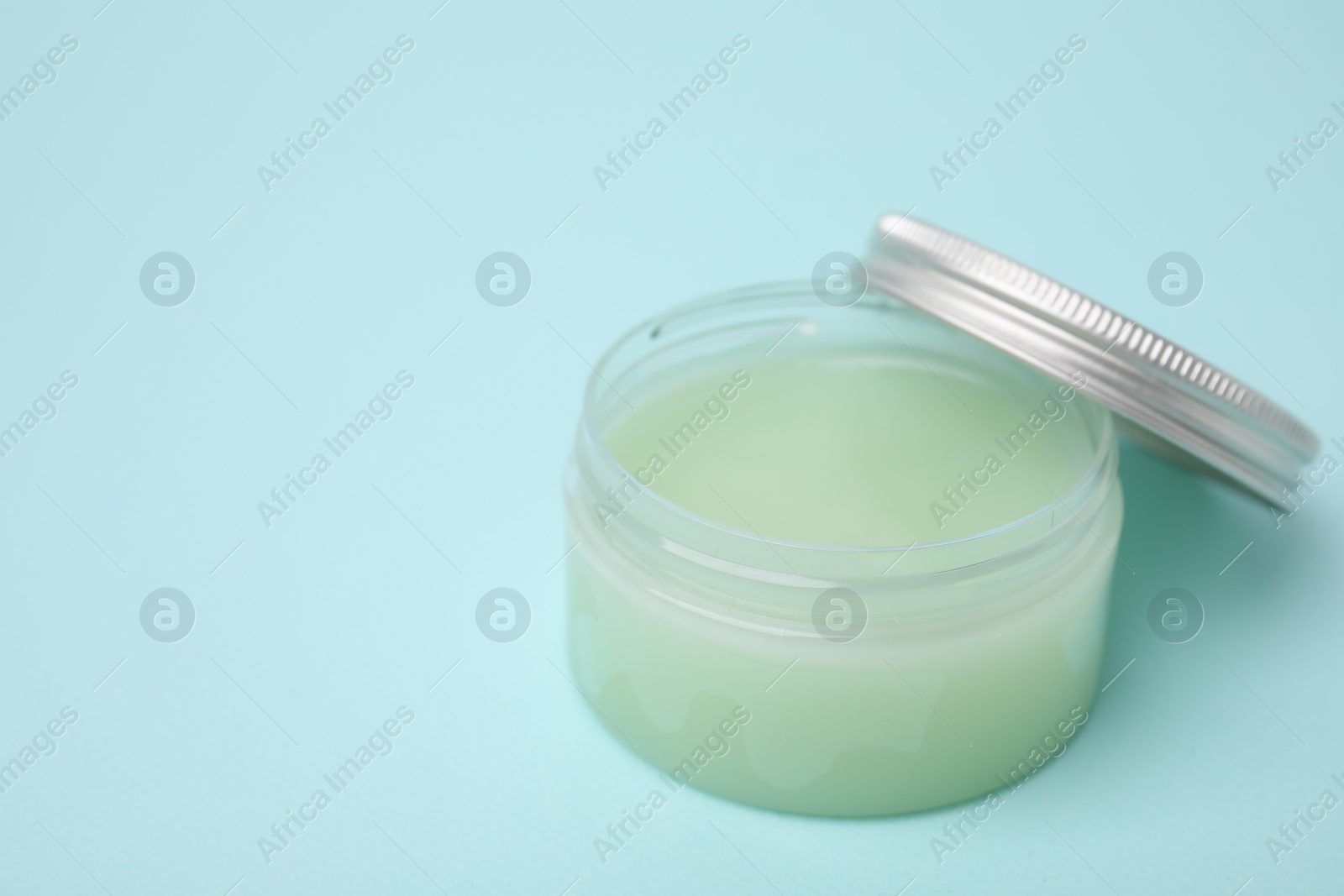 Photo of Jar of petroleum jelly on light blue background. Space for text