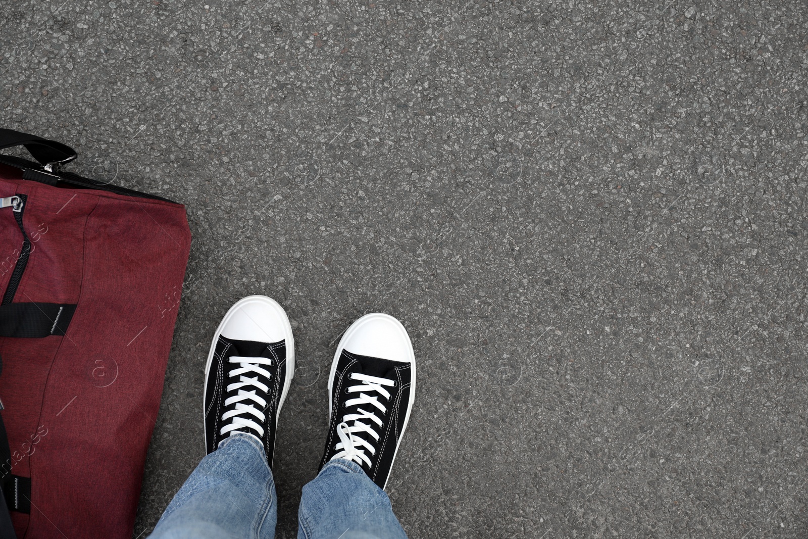 Photo of Man with bag standing on asphalt, top view. Space for text