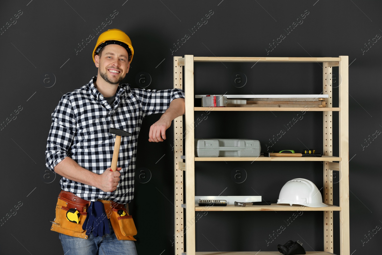 Photo of Handsome working man in hard hat with hammer indoors. Home repair