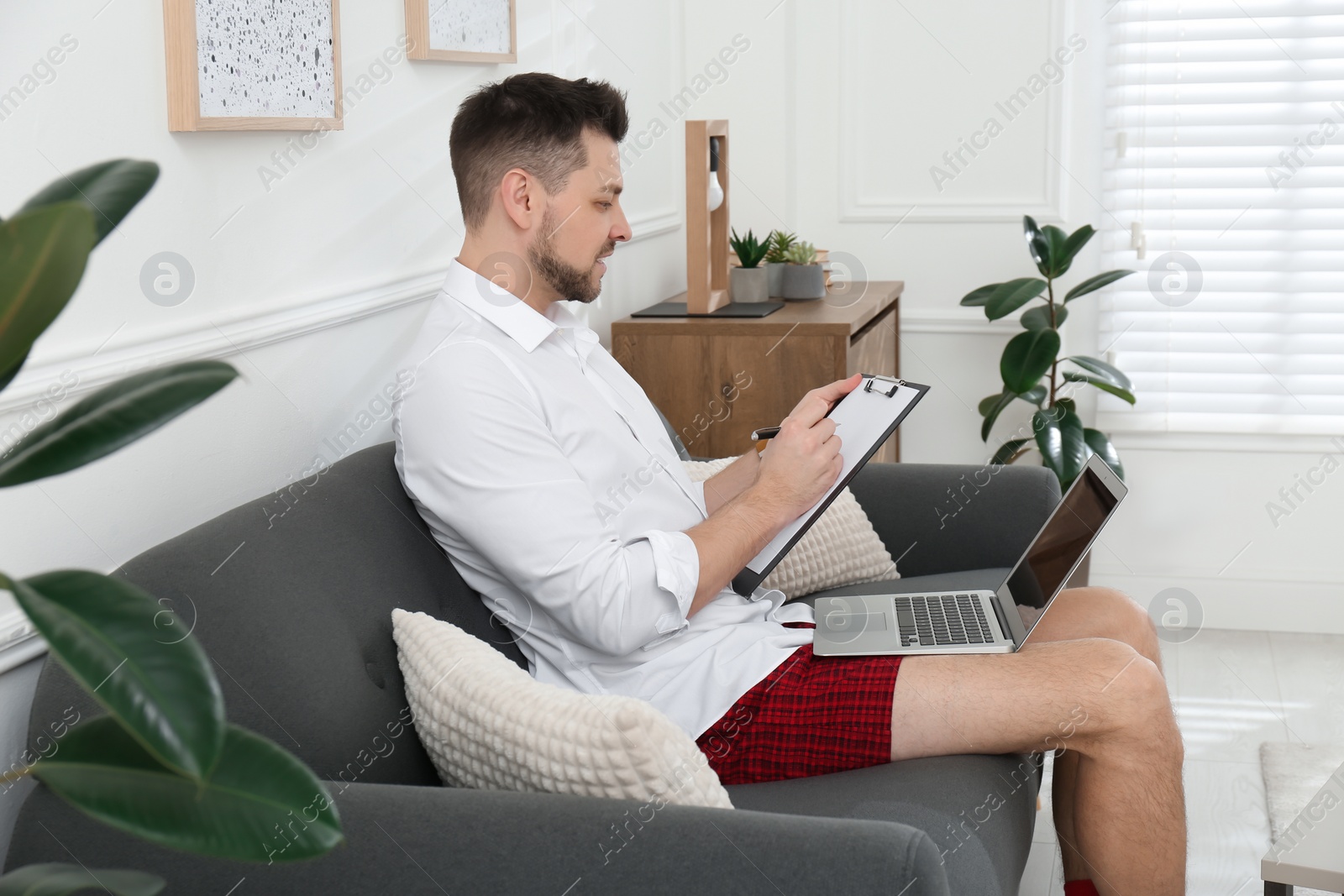 Photo of Businessman wearing shirt and underwear during video call at home