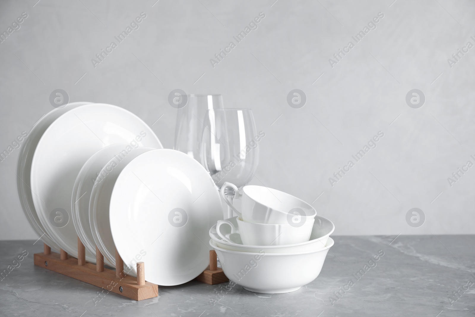 Photo of Set of clean dishware on marble table