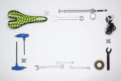 Photo of Set of different bicycle tools and parts on white background, top view. Space for text