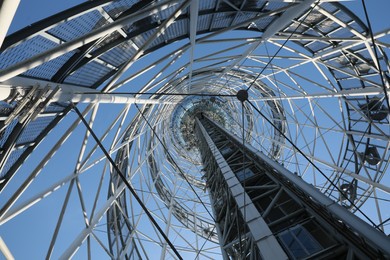 Structure of modern tower against blue sky, bottom view