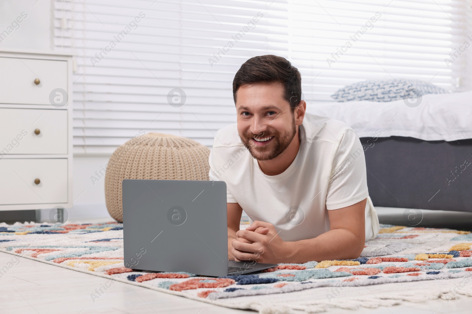 Photo of Happy man and laptop on floor at home