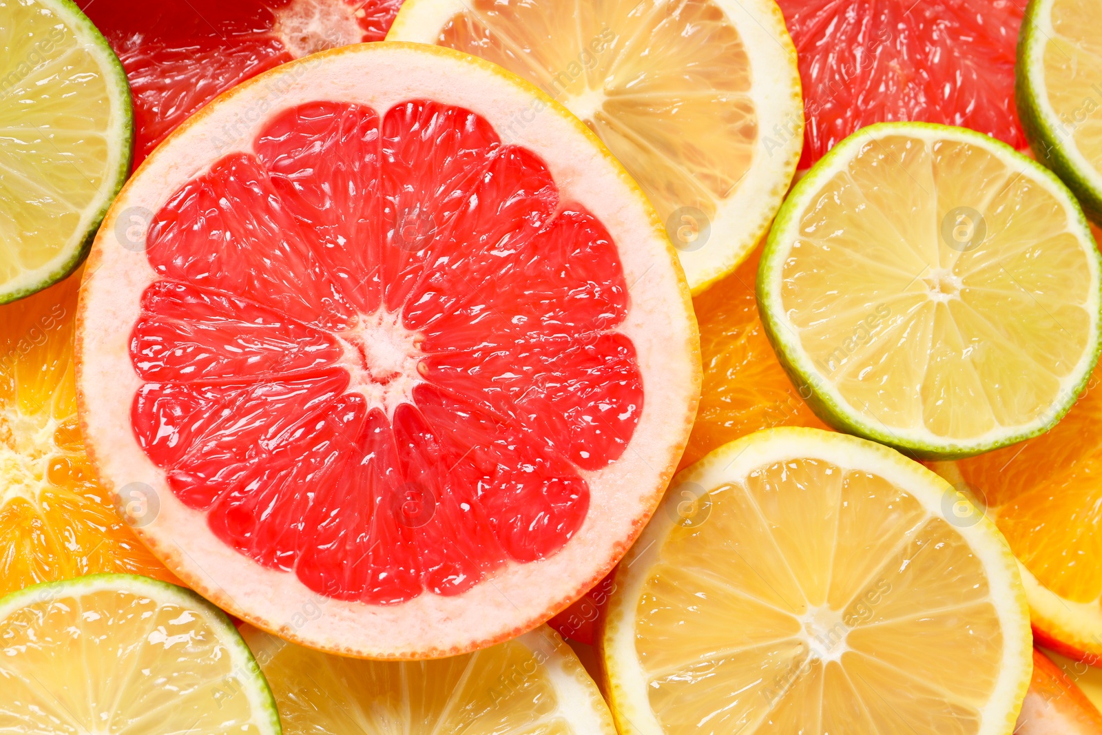 Photo of Different sliced citrus fruits as background, top view