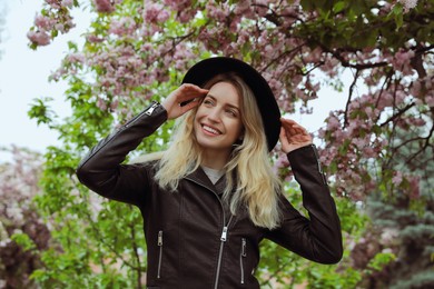 Photo of Beautiful young woman wearing stylish hat on spring day