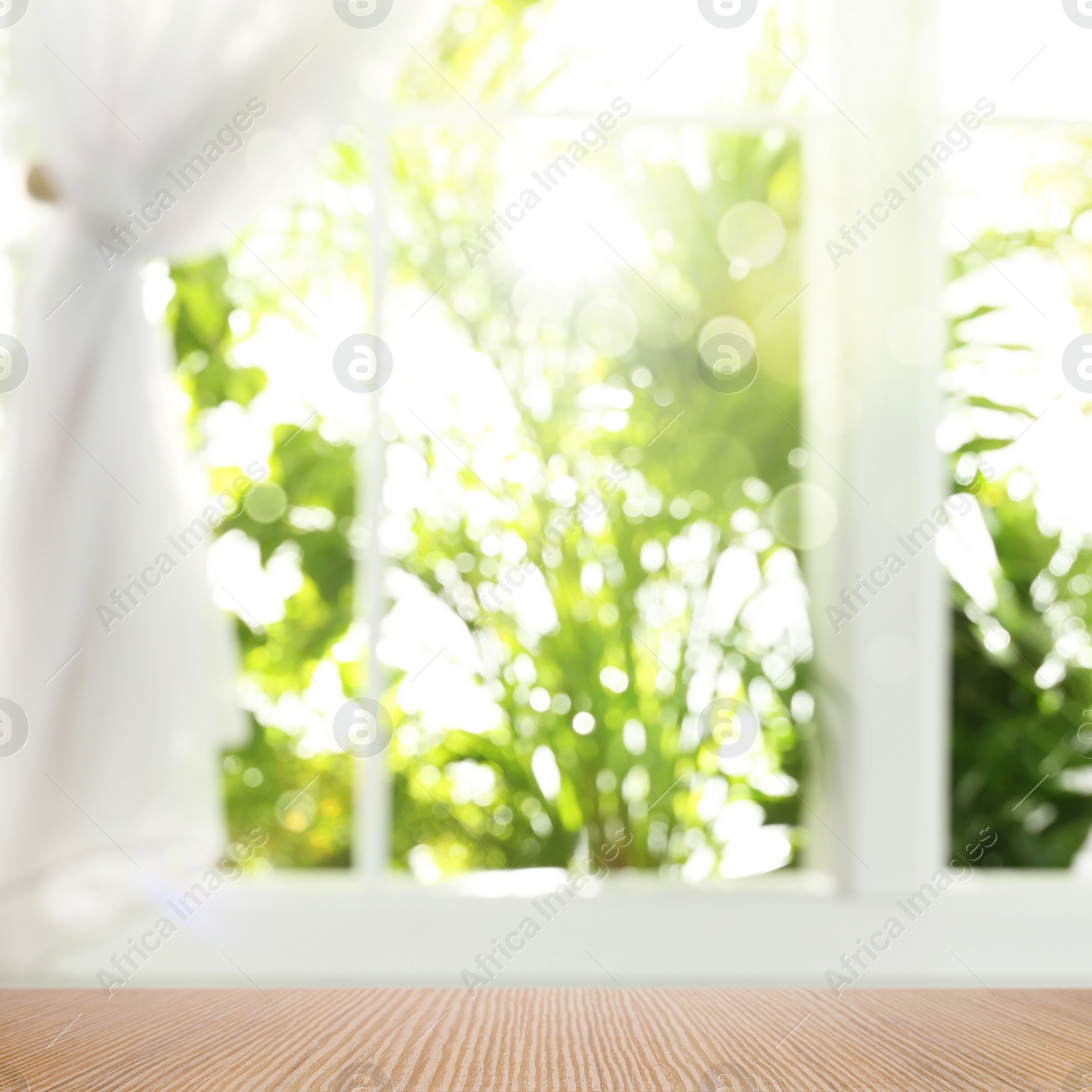 Image of Wooden table and view through window on garden. Springtime