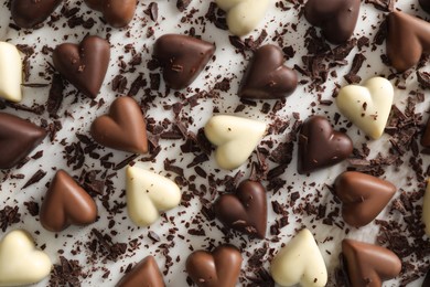 Photo of Beautiful heart shaped chocolate candies on white background, flat lay