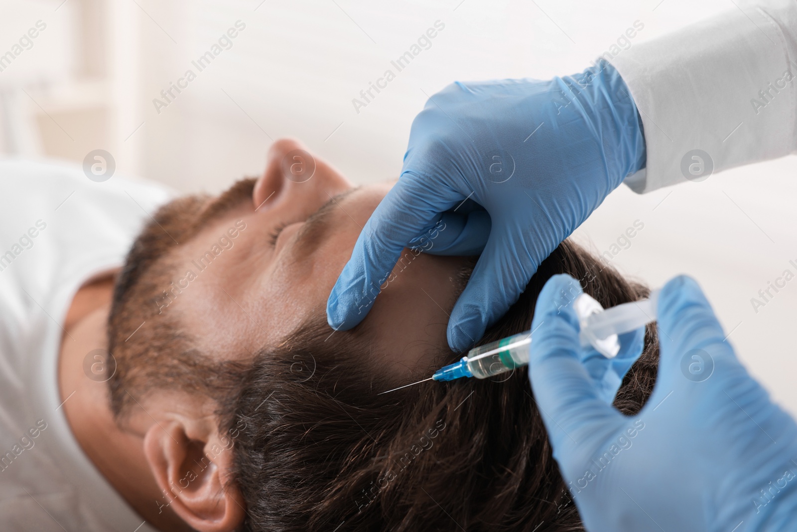 Photo of Trichologist giving injection to patient in clinic, closeup