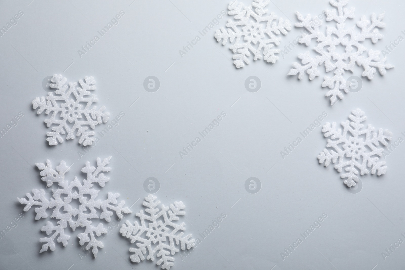 Photo of Beautiful snowflakes on white background, flat lay. Space for text