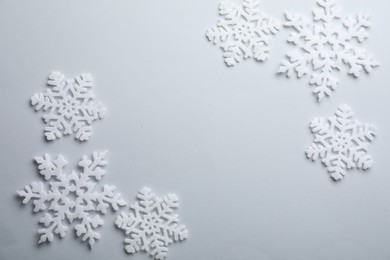 Photo of Beautiful snowflakes on white background, flat lay. Space for text