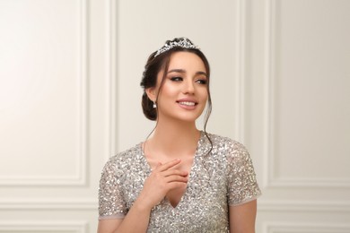 Photo of Beautiful young woman wearing luxurious tiara indoors