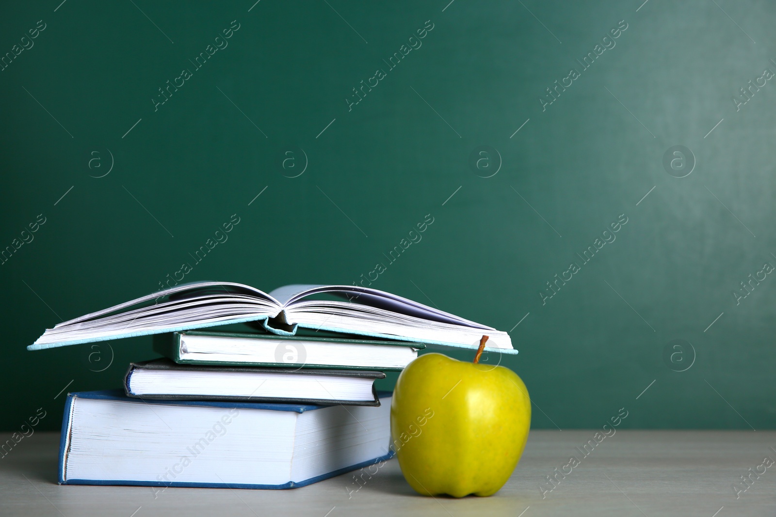 Photo of Apple and stack of books on white wooden table, space for text. Doing homework