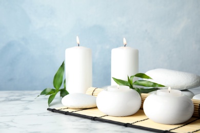 Beautiful spa composition with candles and stones on table, space for text