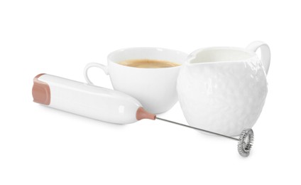 Photo of Mini mixer (milk frother), cup of coffee and pitcher isolated on white