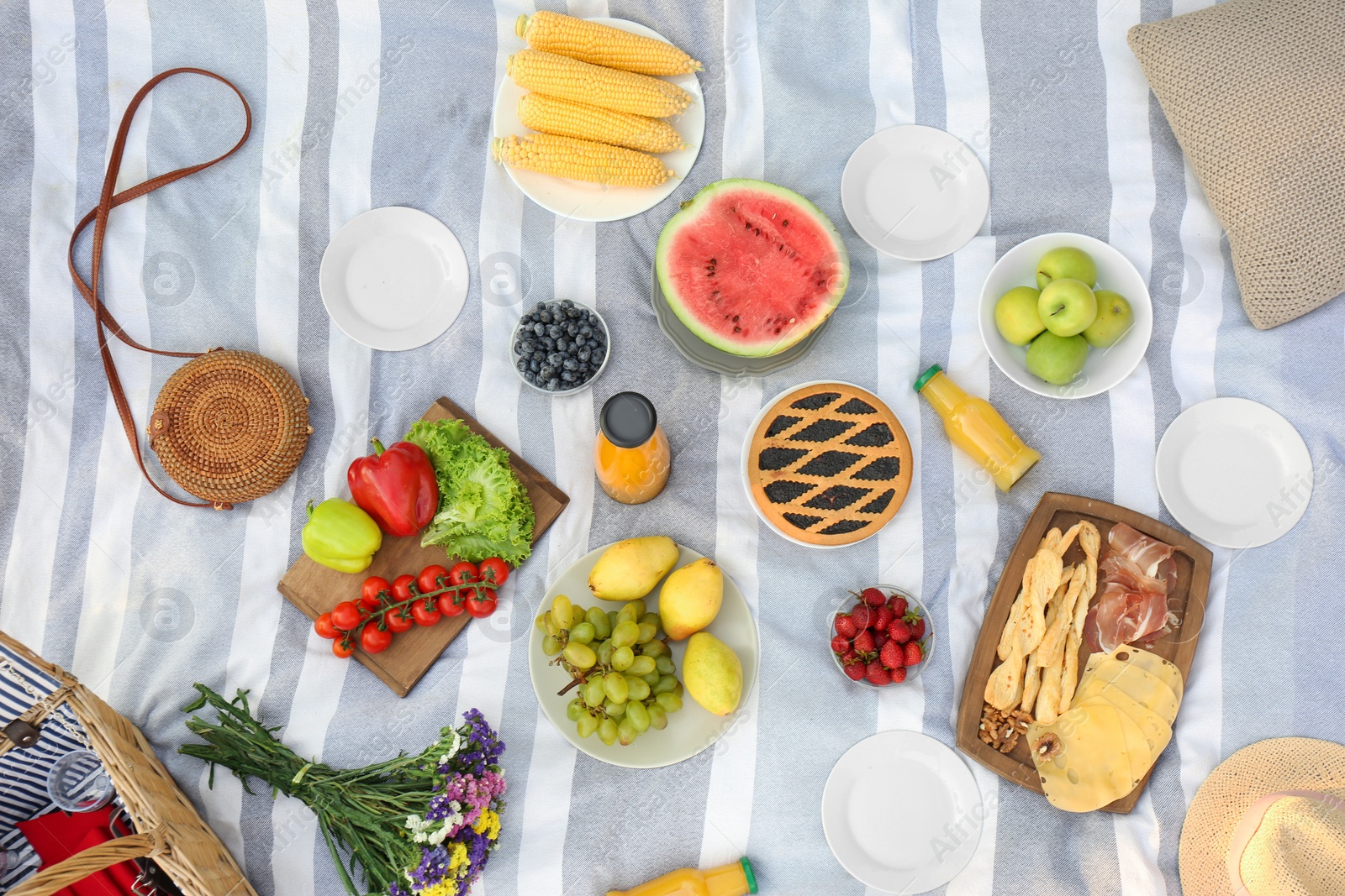 Photo of Picnic blanket with delicious snacks, top view