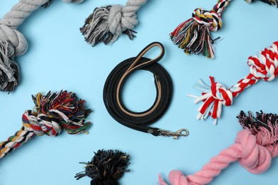 Photo of Flat lay composition with dog leash and toys on light blue background