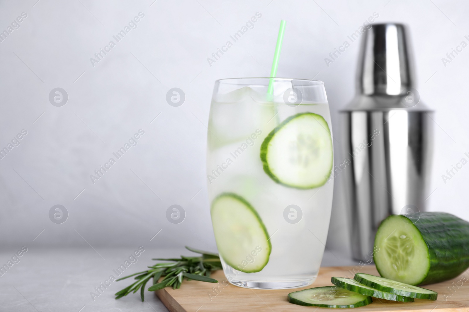 Photo of Composition with glass of cucumber martini on table against light background. Space for text