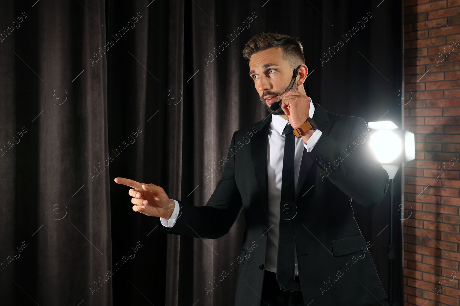 Photo of Motivational speaker with headset performing on stage