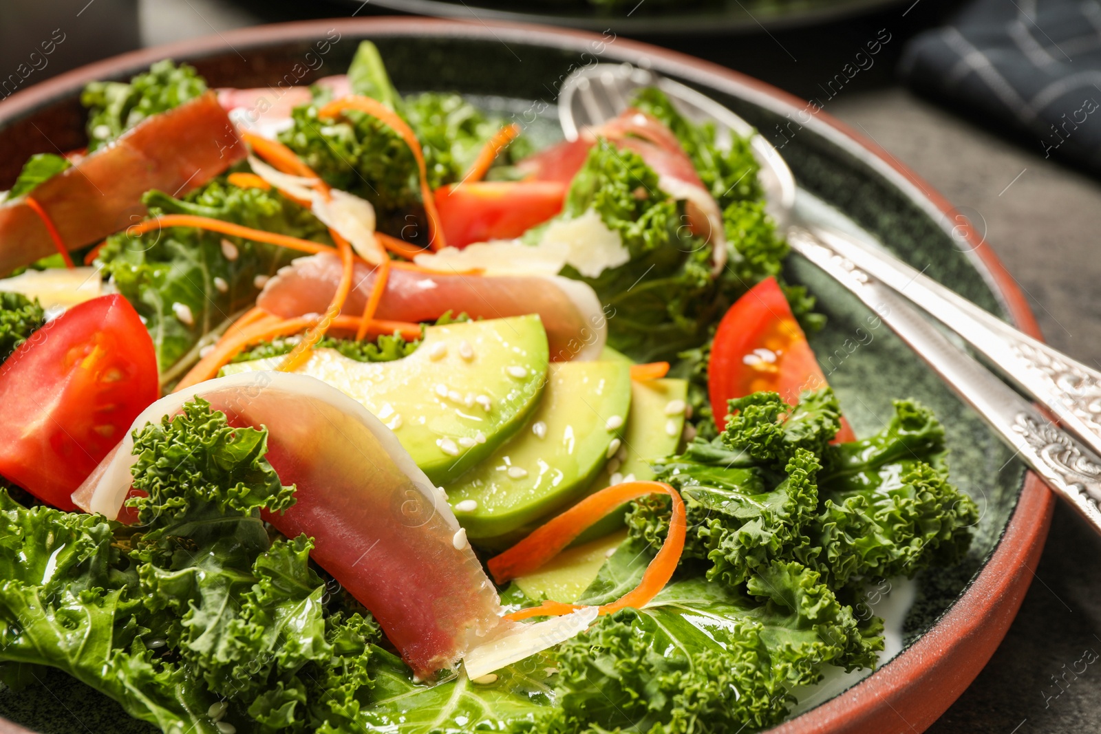 Photo of Delicious kale salad with prosciutto on table, closeup