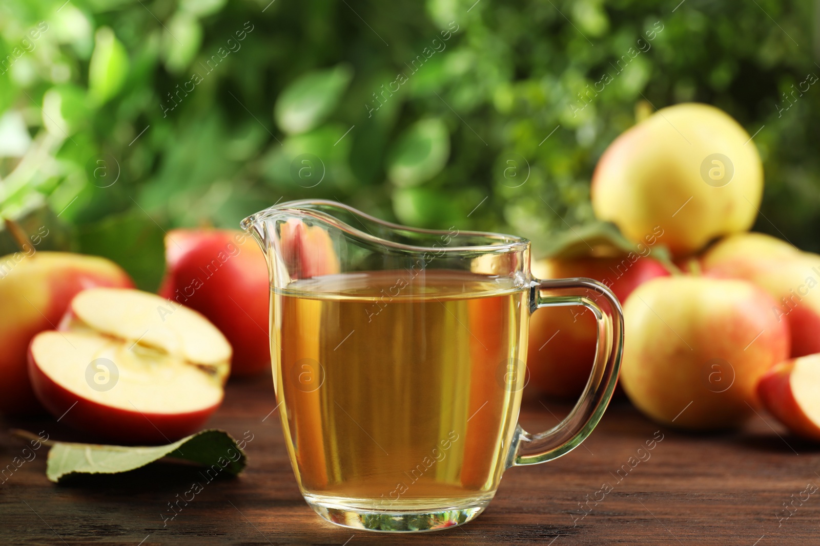 Photo of Natural apple vinegar and fresh fruits on wooden table