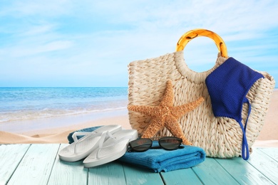 Image of Beach accessories on turquoise wooden surface near ocean 