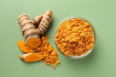 Aromatic turmeric powder and raw roots on green background, flat lay