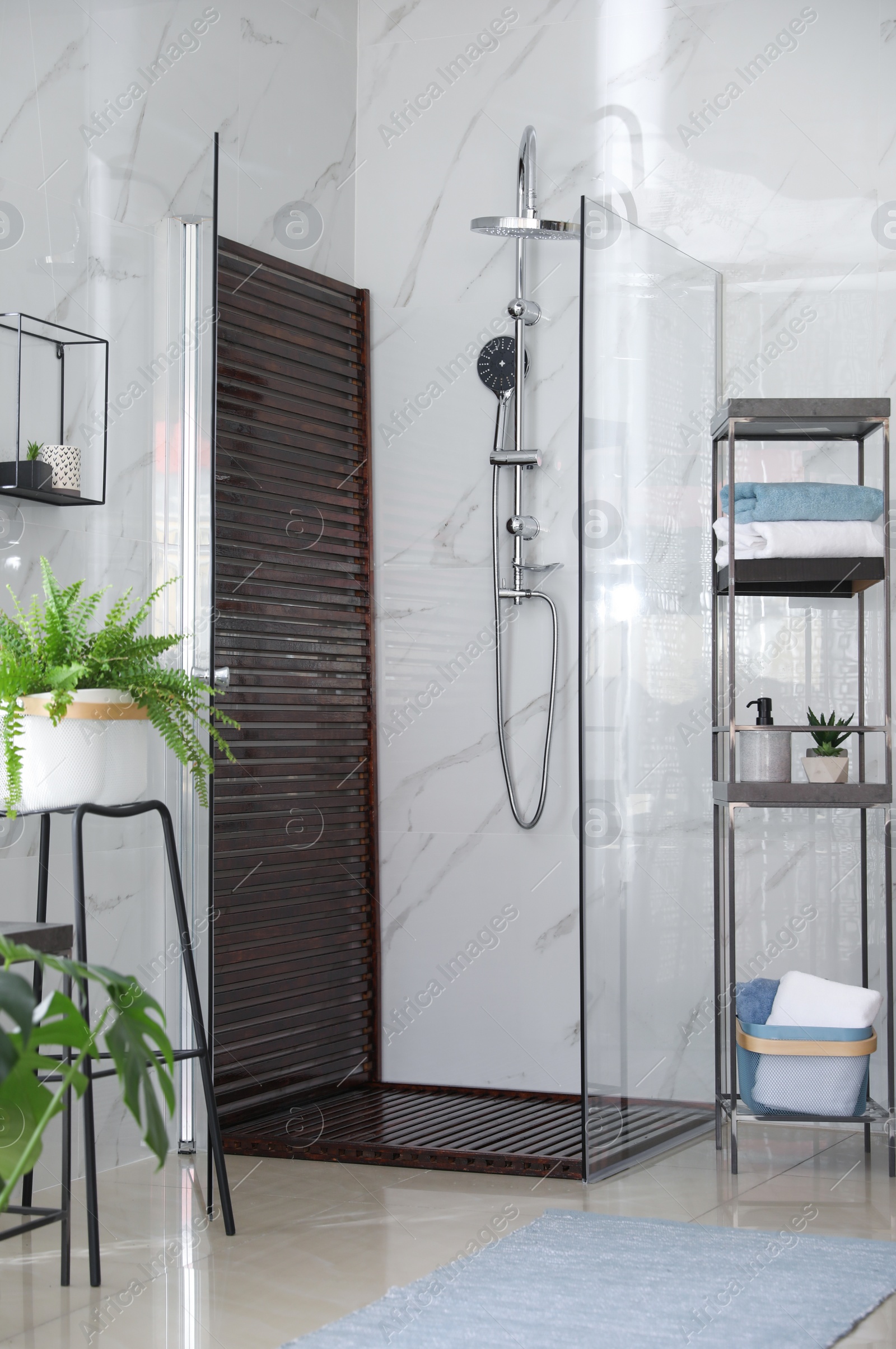 Photo of Bathroom interior with shower stall and shelving unit. Idea for design