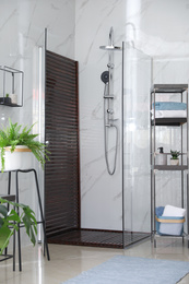 Photo of Bathroom interior with shower stall and shelving unit. Idea for design