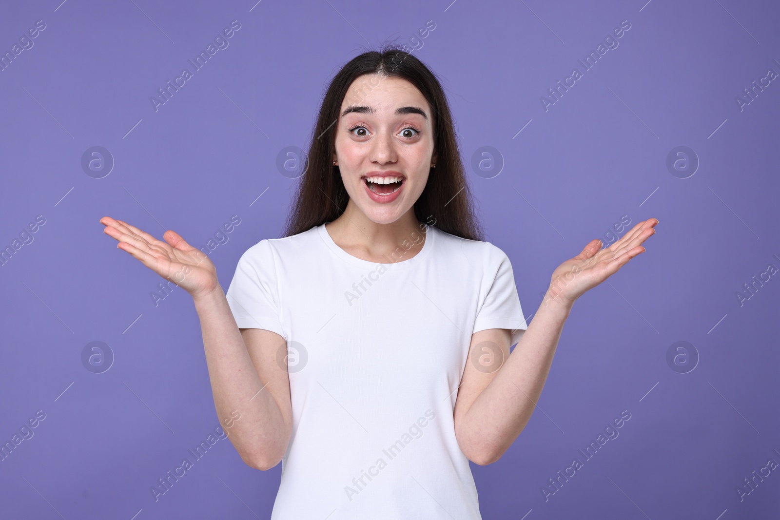 Photo of Portrait of happy surprised woman on violet background